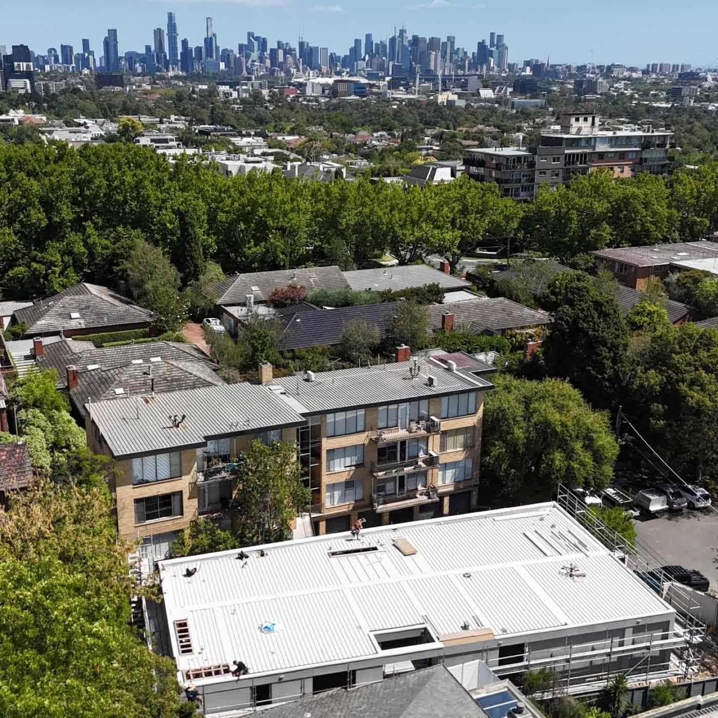 Drone over Toorak rooftops with the Melbourne skyline