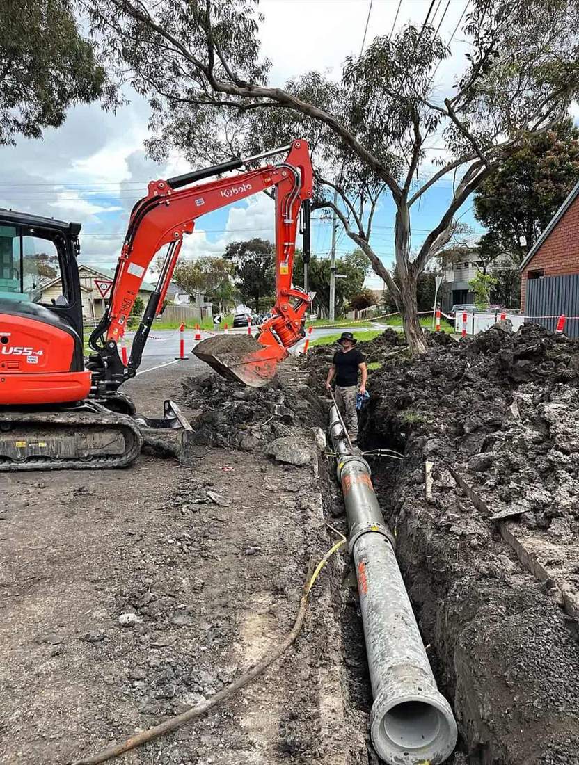 Civil drainage installation with excavator on site